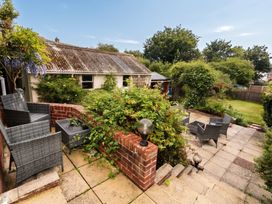 A garden with seating area and plants at Tudor Rose in Weymouth
