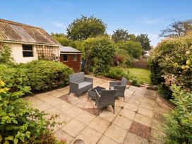 A garden with outdoor chairs and a table at Tudor Rose in Weymouth