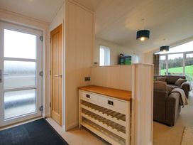 An entrance area with a wine rack and a television at 5 Hillview Lodges in Cleobury Mortimer