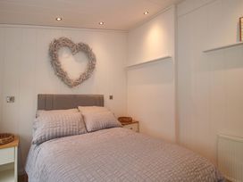 A bedroom with a bed and wall decor at 5 Hillview Lodges Cleobury Mortimer