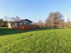 A house with a deck on a lawn at Moorland View