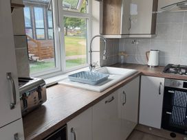 A kitchen with a sink and dish rack at Moorland View in Dobwalls