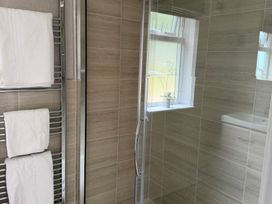 A bathroom with towels on a rack and a shower at Moorland View in Dobwalls