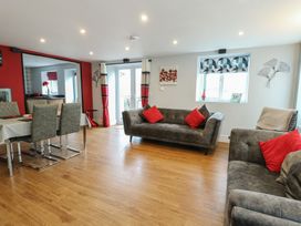 A living room with sofas and a dining area at Ty Llyn in Brynteg near Benllech