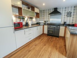 A kitchen with appliances and utensils at Ty Llyn Brynteg near Benllech