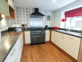 A kitchen with a stove and sink at Ty Llyn in Brynteg near Benllech