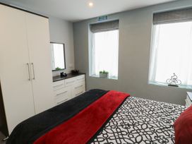 A bedroom with a bed and wardrobe at Ty Llyn Brynteg near Benllech