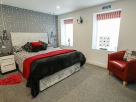 A bedroom with a bed and chair at Ty Llyn in Brynteg near Benllech