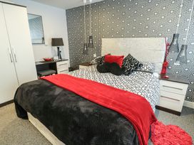 A bedroom with a bed and nightstand at Ty Llyn Brynteg near Benllech