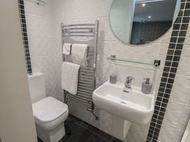 A bathroom with toilet, towel rack, and hand basin at Ty Llyn in Brynteg near Benllech