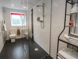 A bathroom with a shower, toilet, and sink at Ty Llyn in Brynteg near Benllech