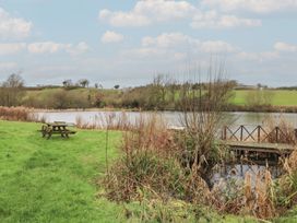 A picnic table near a water body at Ty Llyn in Brynteg near Benllech