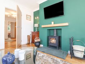 A living room with a fireplace and television at Wansfell View in Ambleside