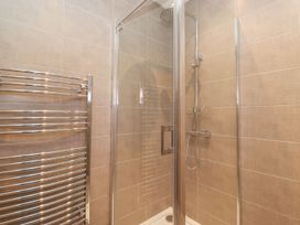 A shower with glass door and towel rail at Wansfell View in Ambleside