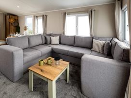 A living room featuring a grey sofa and a wooden coffee table at Ashberry 39 x 12 Three Bed- 2, Northwich