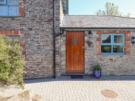 An entrance with a wooden door and stone wall at Pillars in Barnstaple