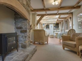 A conservatory with wicker chairs and a dining table at Pillars in Barnstaple