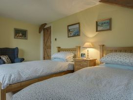 A bedroom with two beds and a chair at Pillars in Barnstaple