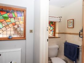 A bathroom featuring a toilet and stained glass window at Pillars, Barnstaple