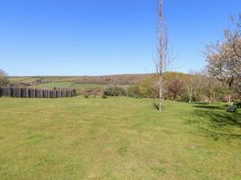 A garden with trees and a fence at Pillars in Barnstaple