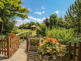 A garden with a footbridge and gazebo at Pillars in Barnstaple