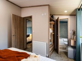 A bedroom with a bed and wardrobe at No 8 Sandstone Lodge Sanctuary Northwich