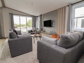 A living room with sofa and television at Cedar Lodge 3 Bedrooms Delamere