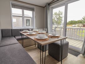 A dining area with a table set for meals at Cedar Lodge 3 Bedrooms in Delamere