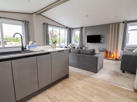 A living room with a sofa and television at Cedar Lodge 3 Bedrooms Delamere