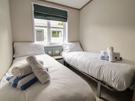 A bedroom with two beds and towels at Cedar Lodge 3 Bedrooms in Delamere