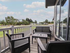 An outdoor area with a balcony and seating at Cedar Lodge 3 Bedrooms in Delamere