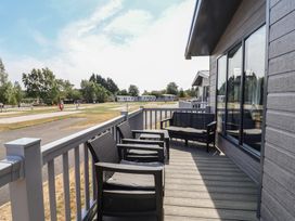 An outdoor area with chairs and table at Cedar Lodge 3 Bedrooms Delamere