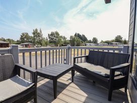 A patio area with chairs and a table at Cedar Lodge 3 Bedrooms Delamere