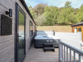 An outdoor area with a hot tub and seating at No.11 - Cedar Lodge, Delamere