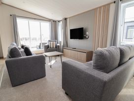 A living room with a sofa, coffee table, and television at No.11 - Cedar Lodge, Delamere