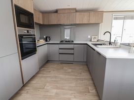A kitchen with cabinets, appliances, and a sink at No.11 - Cedar Lodge, Delamere