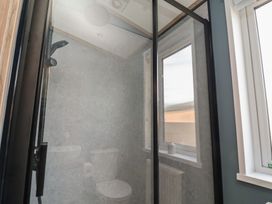 A shower with a toilet and window in the bathroom at No.11 - Cedar Lodge in Delamere