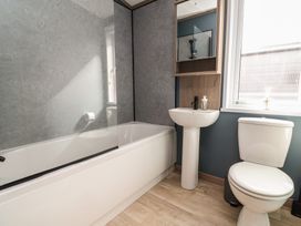 A bathroom with bathtub, sink, and toilet at No.11 - Cedar Lodge in Delamere