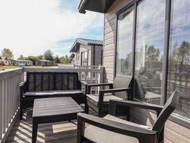 A balcony with chairs and a table at No.11 - Cedar Lodge in Delamere