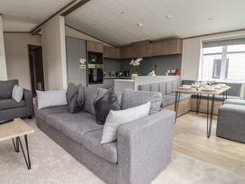 A living room with a sofa and dining table at Cedar Lodge 3 Bedrooms with hot tub Delamere