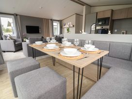 A dining area with table set for meals at Cedar Lodge 3 Bedrooms with hot tub in Delamere