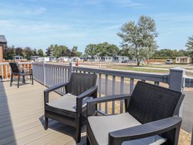 An outdoor area with chairs and a pathway at Cedar Lodge 3 Bedrooms with hot tub, Delamere