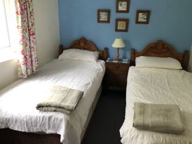 A bedroom with two beds and a nightstand at 12 Glyn terrace Borth-Y-Gest