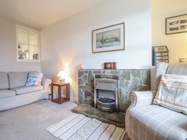 A living room with a fireplace and sofa at 12 Glyn Terrace Borth-Y-Gest