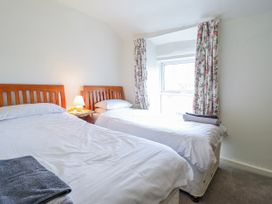 A bedroom with two beds and a bedside table at 12 Glyn Terrace Borth-Y-Gest