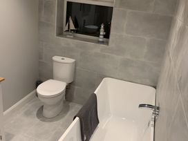 A bathroom with a tub and toilet at 43 Goose Green Road in King's Lynn