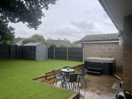 A garden with a table and chairs near a hot tub at 43 Goose Green Road in King's Lynn