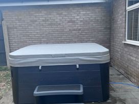 A hot tub with cover and steps in an outdoor area at 43 Goose Green Road King's Lynn