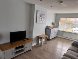 A living room with a television and furniture at 15 Lamsey Lane in King's Lynn