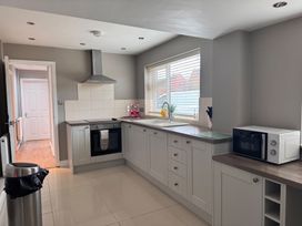 A kitchen with an oven, sink, microwave, and trash can at 15 Lamsey Lane in King's Lynn